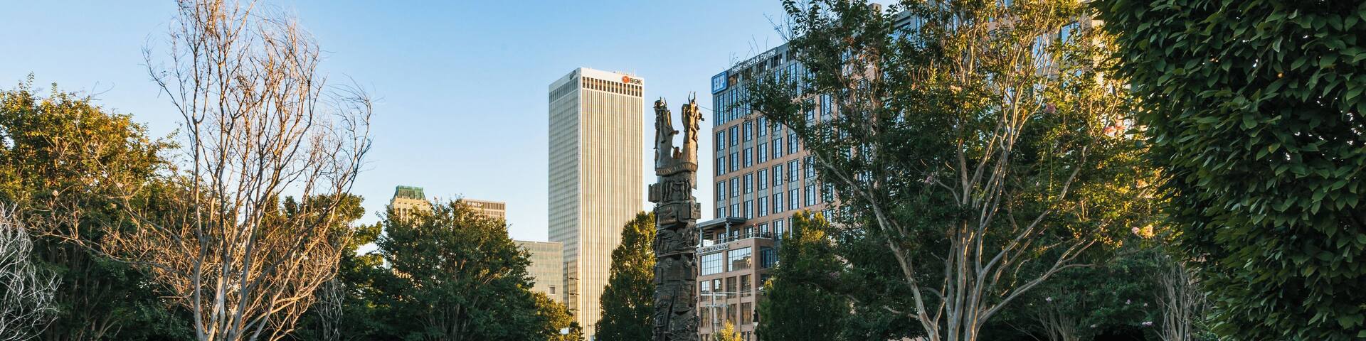 Un parque con una escultura, una fuente y un cartel que dice 'Tower of Reconciliation'.
