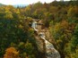Aerial drone view of Autumn / Fall foliage of River and Waterfall in the Blue Ridge Mountains of Asheville, North Carolina.