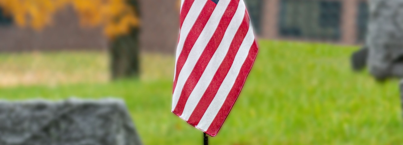 American flags flying on graves during Veterans Day 2020 in Upstate NY while light rain is falling.
