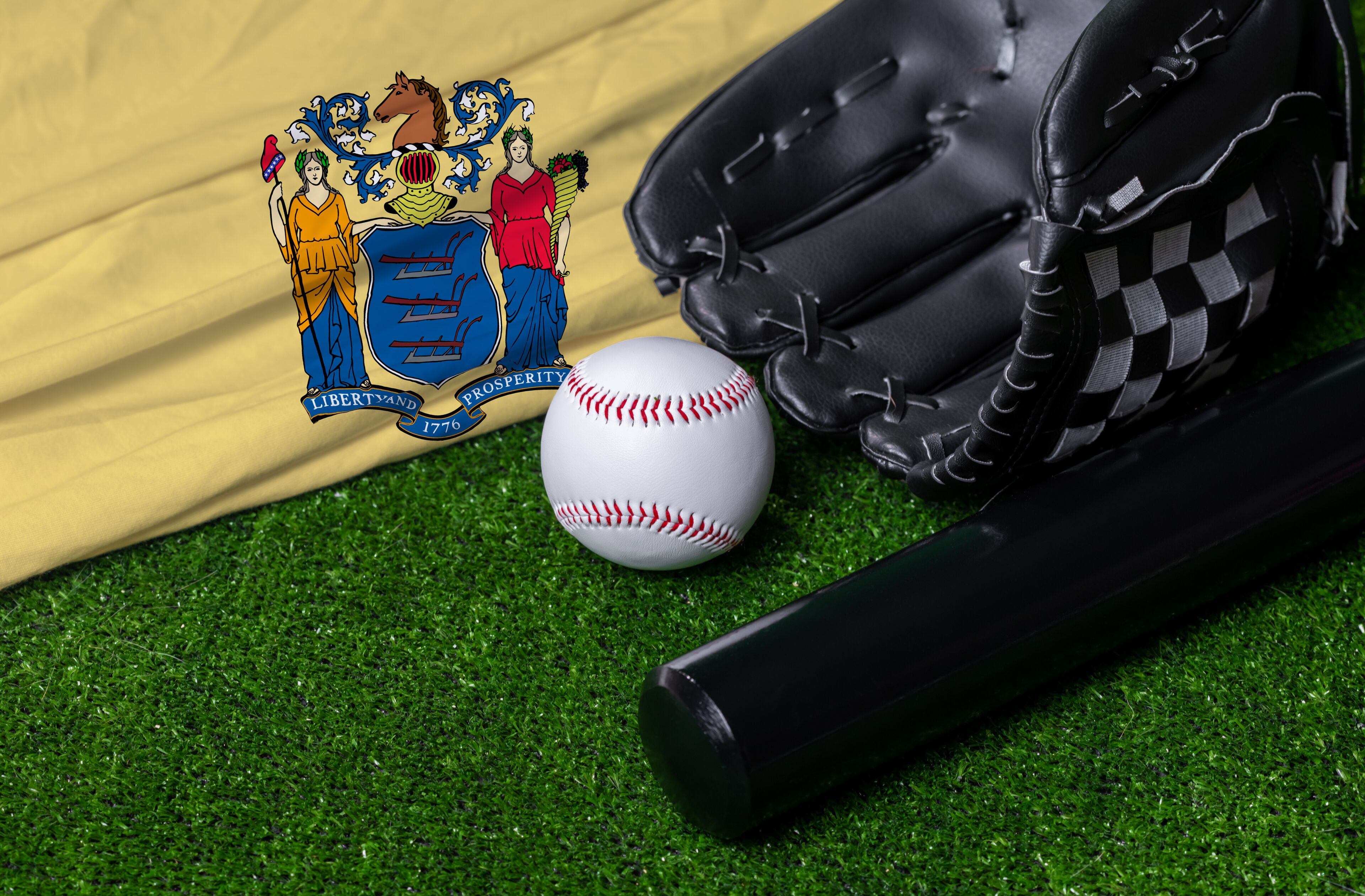 Baseball bat, glove and ball near New Jersey flag on green grass background