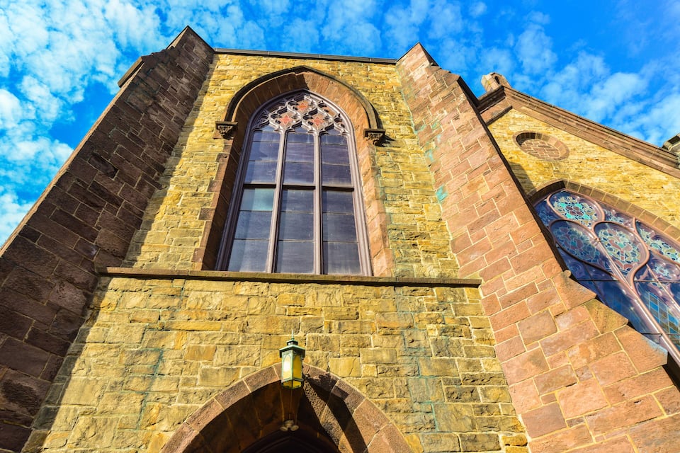 A historic building with a large arched window and intricate stained glass.