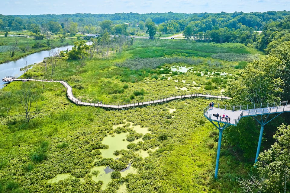 Un río, una pasarela y una zona boscosa.