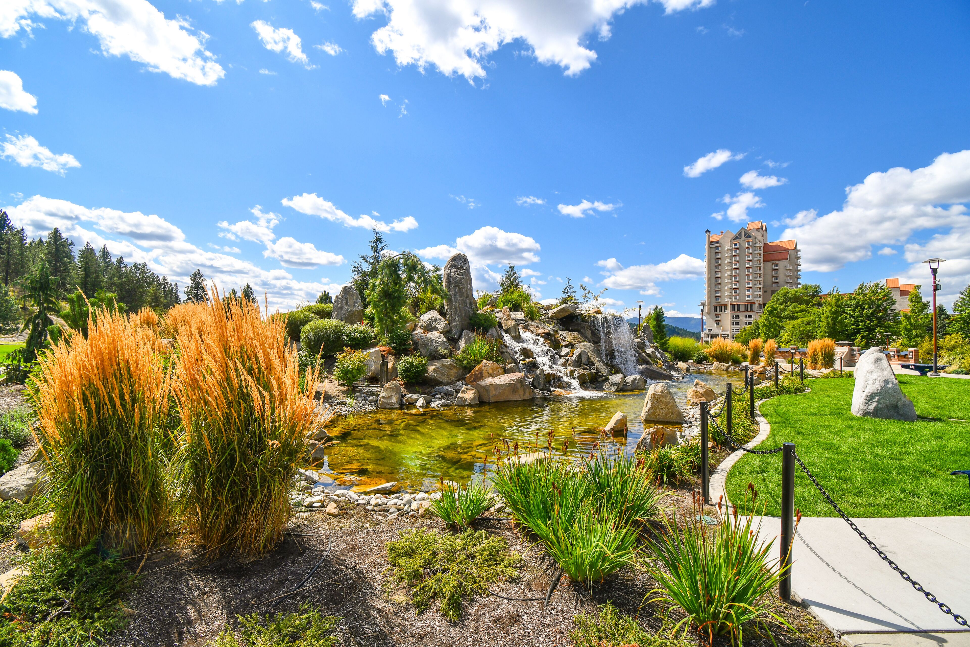 A large pond with waterfall inside the public McEuen Park near resorts and Tubbs Hill in the lakefront town of Coeur d'Alene, Idaho.