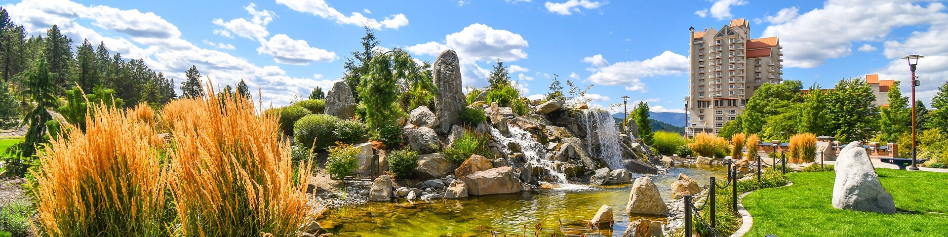 A large pond with waterfall inside the public McEuen Park near resorts and Tubbs Hill in the lakefront town of Coeur d'Alene, Idaho.