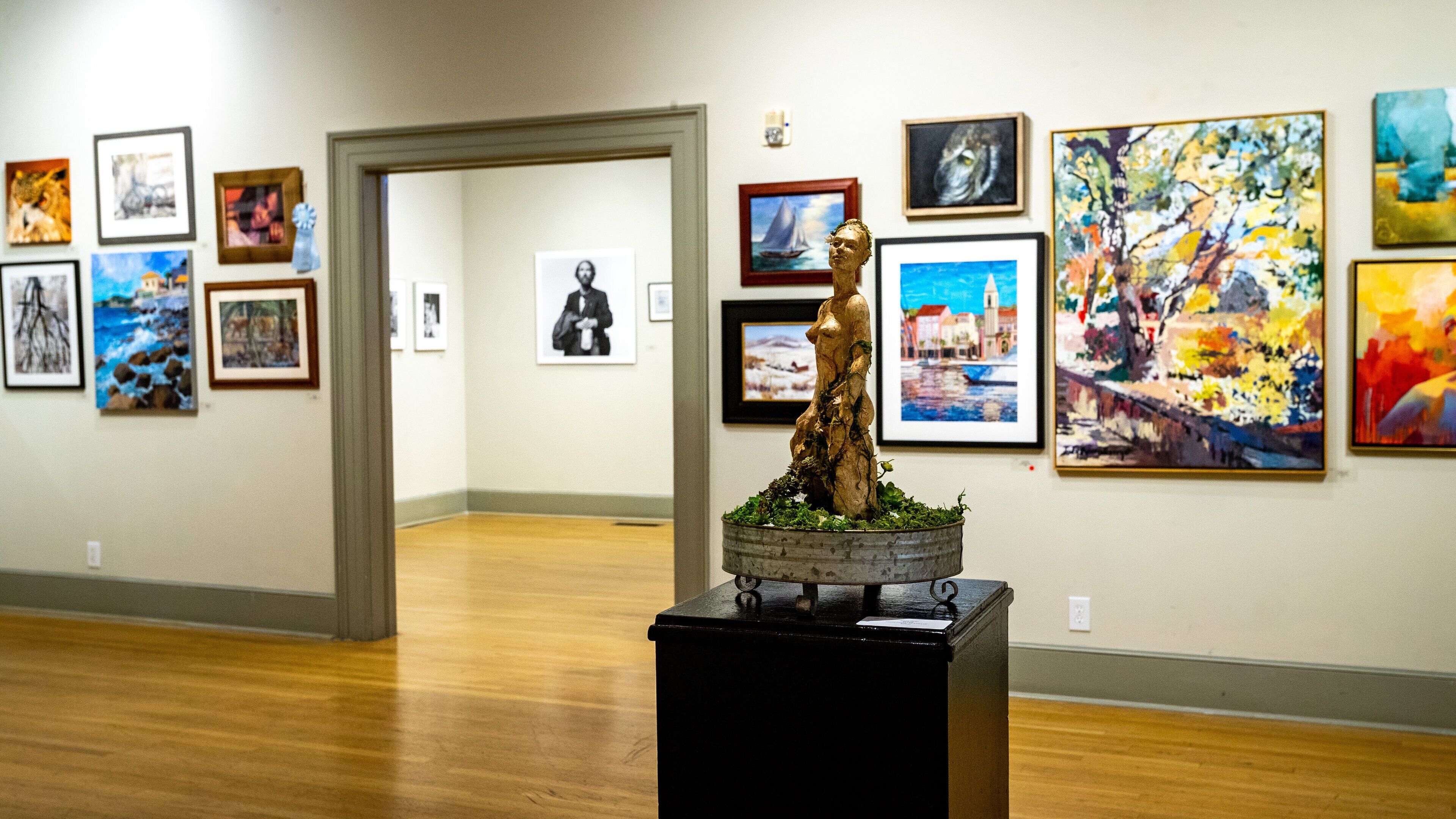 An art gallery with various paintings and sculptures on display.