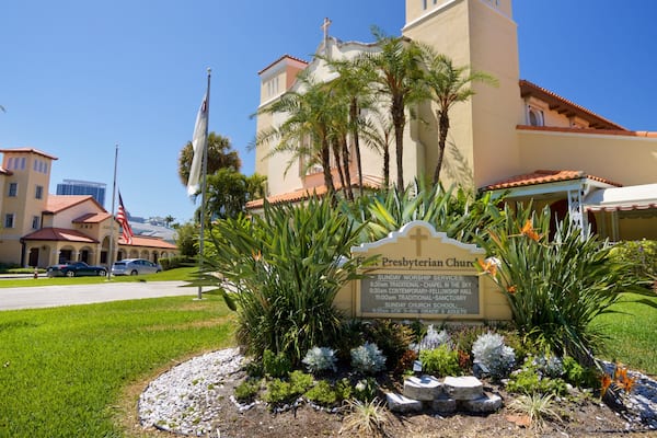 First Presbyterian Church featuring a church or cathedral, signage and flowers