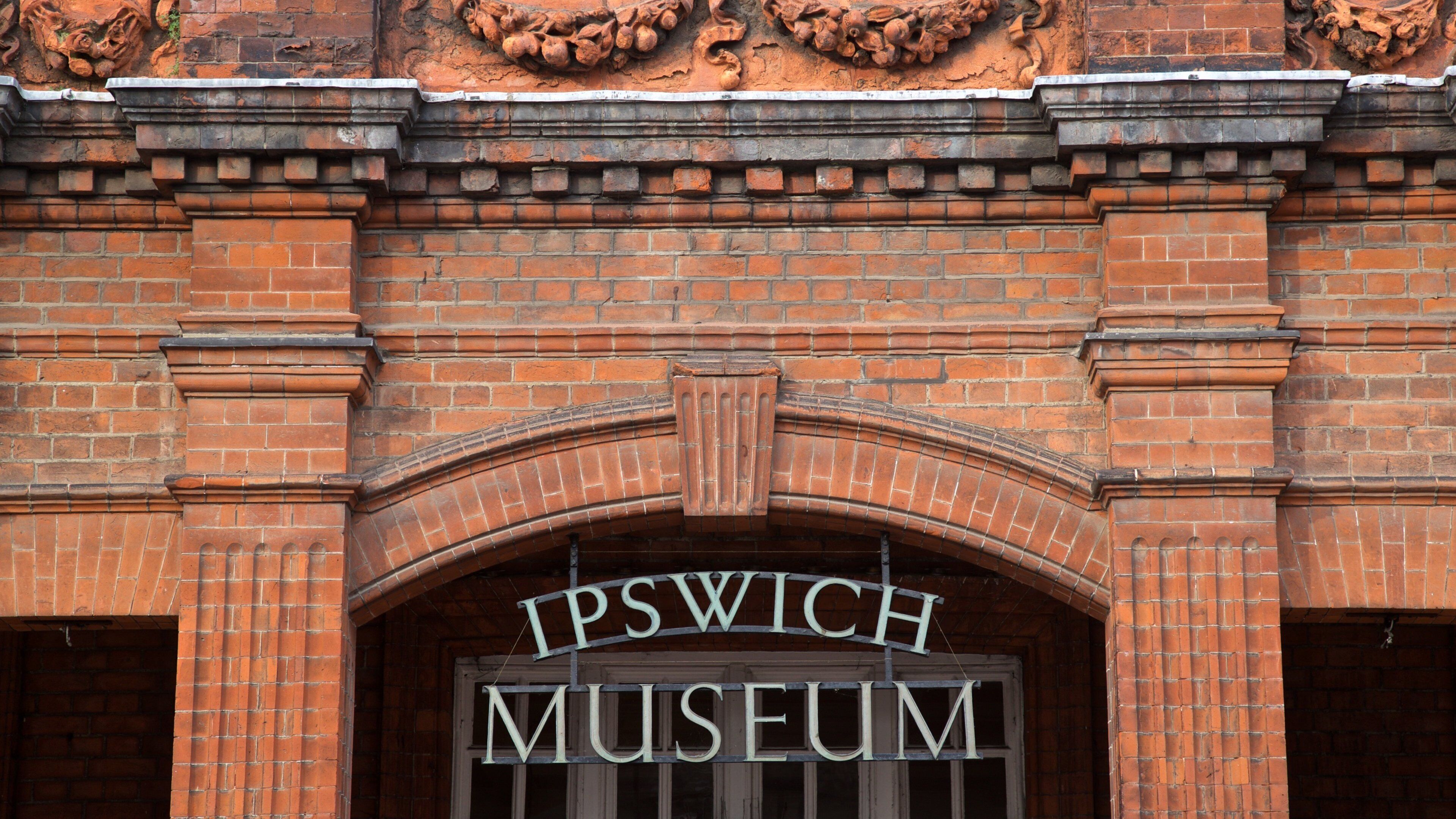 The Ipswich Museum sign on a brick building.