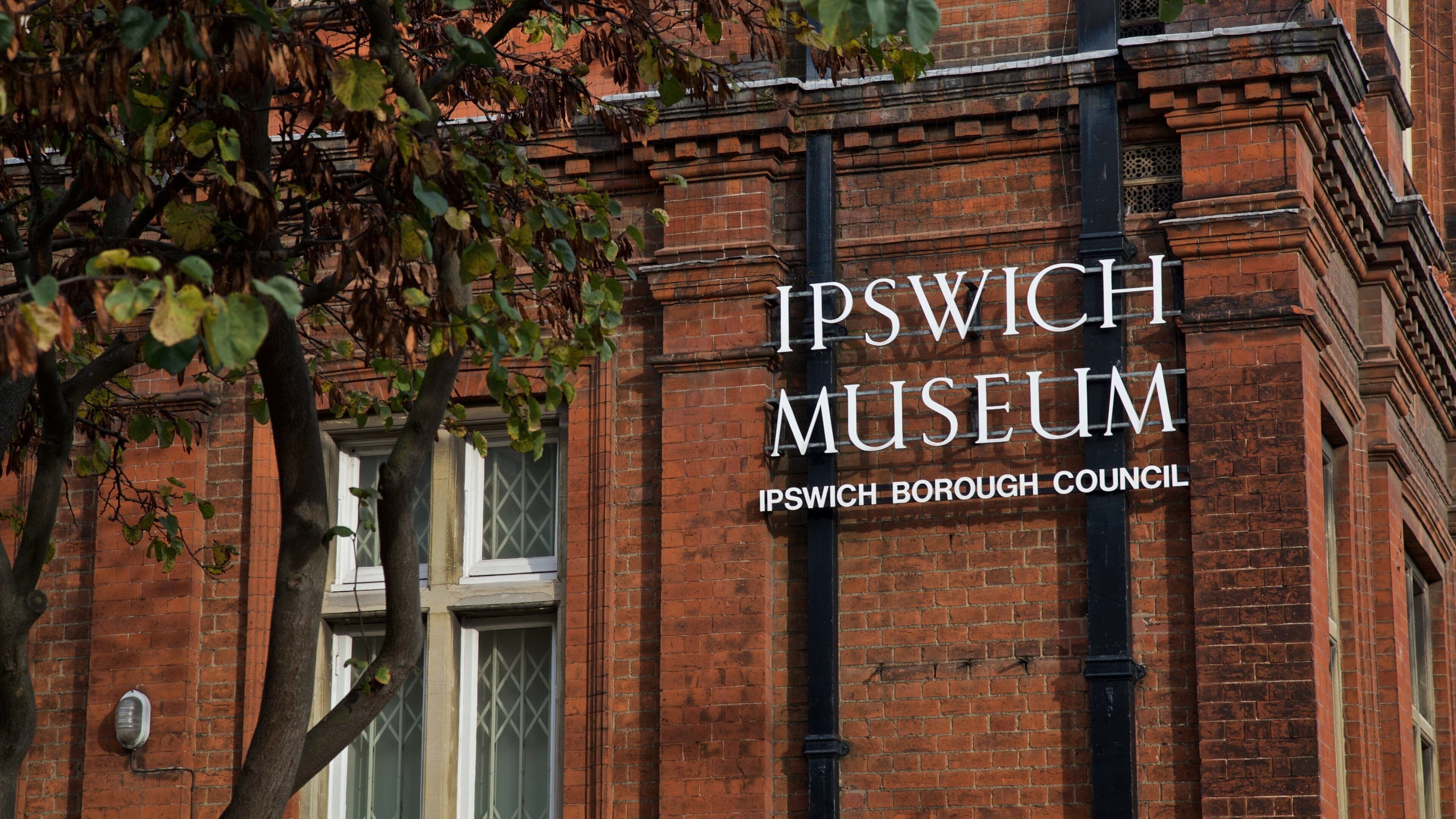 A brick building with the text "Ipswich Museum Ipswich Borough Council" on it.