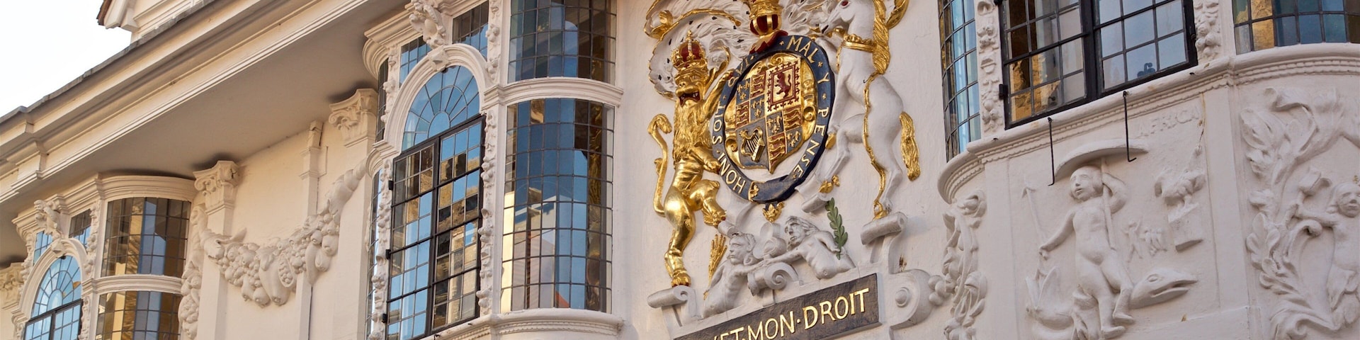 Detalles arquitectónicos ornamentales, incluyendo un escudo de armas y la inscripción 'DIEVET-MOORT'.
