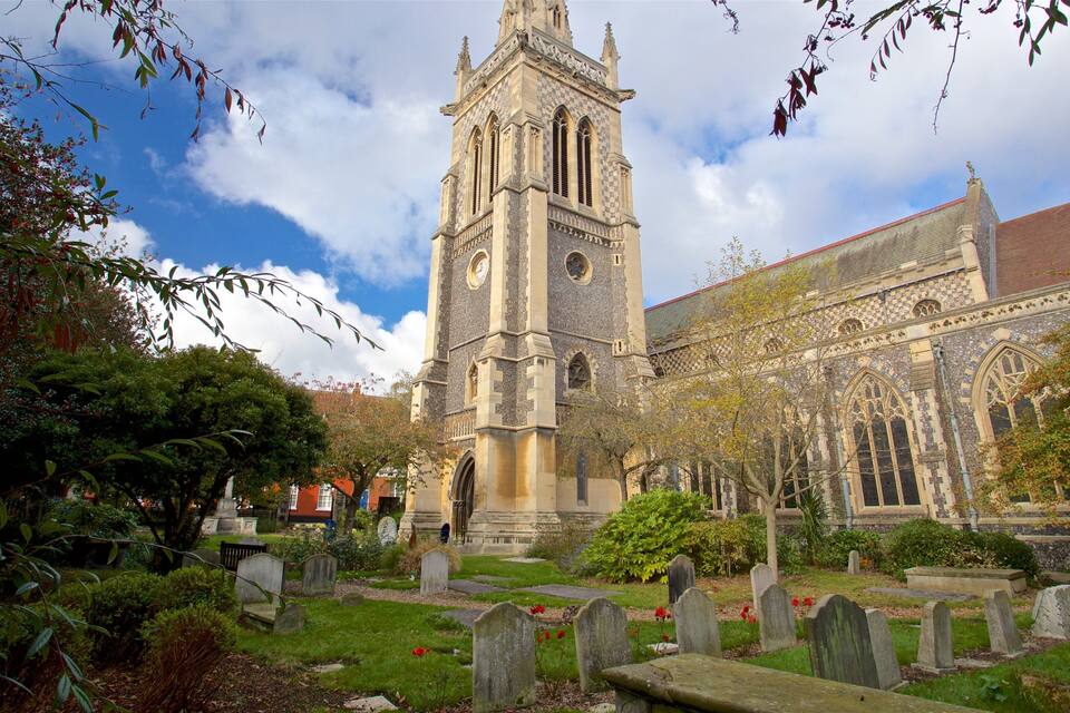 A historic church with a tall tower and a cemetery in the foreground.