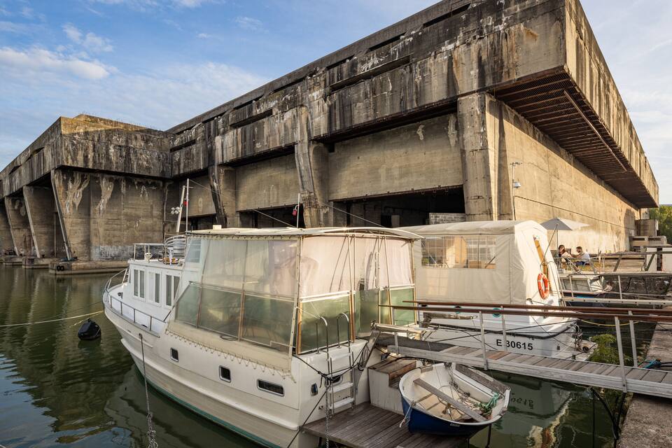 A large concrete dam with boats docked in front.
