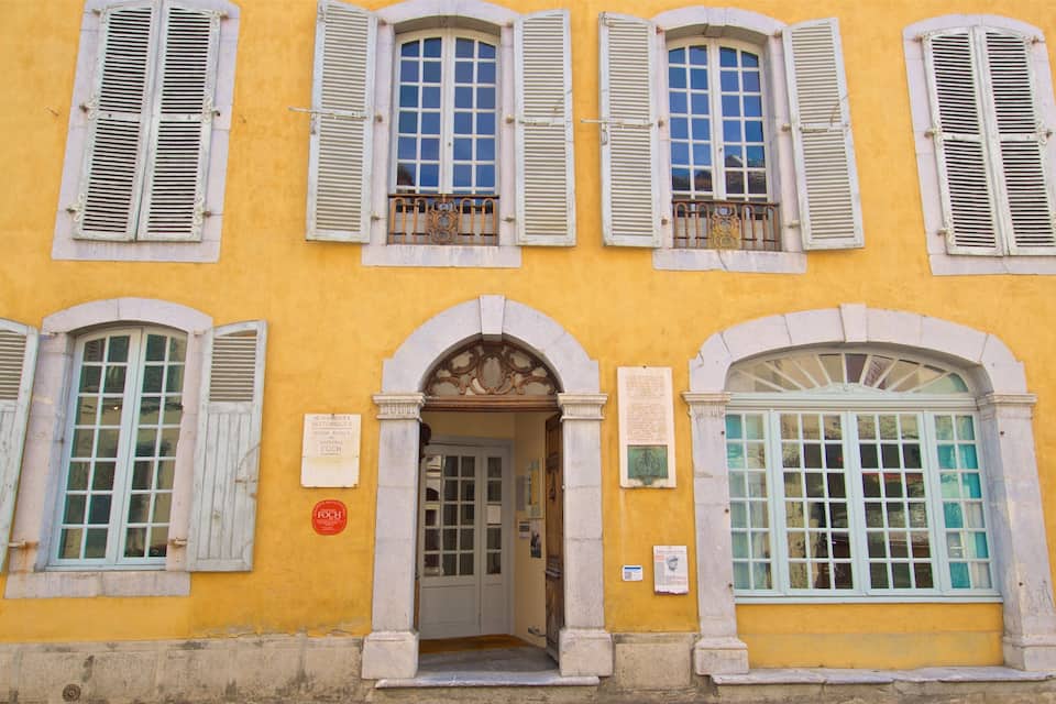 Um edifício amarelo com portadas brancas e uma placa com a inscrição "RUE DE LA VICTOIRE".