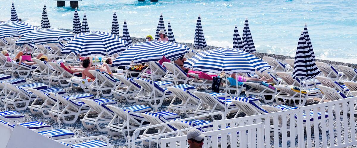 Beach umbrellas and lounge chairs on the beach, Nice, France