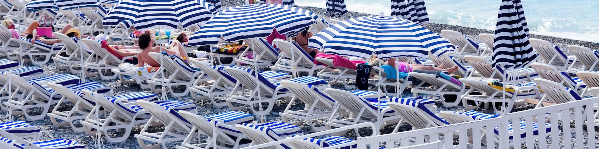 Beach umbrellas and lounge chairs on the beach, Nice, France