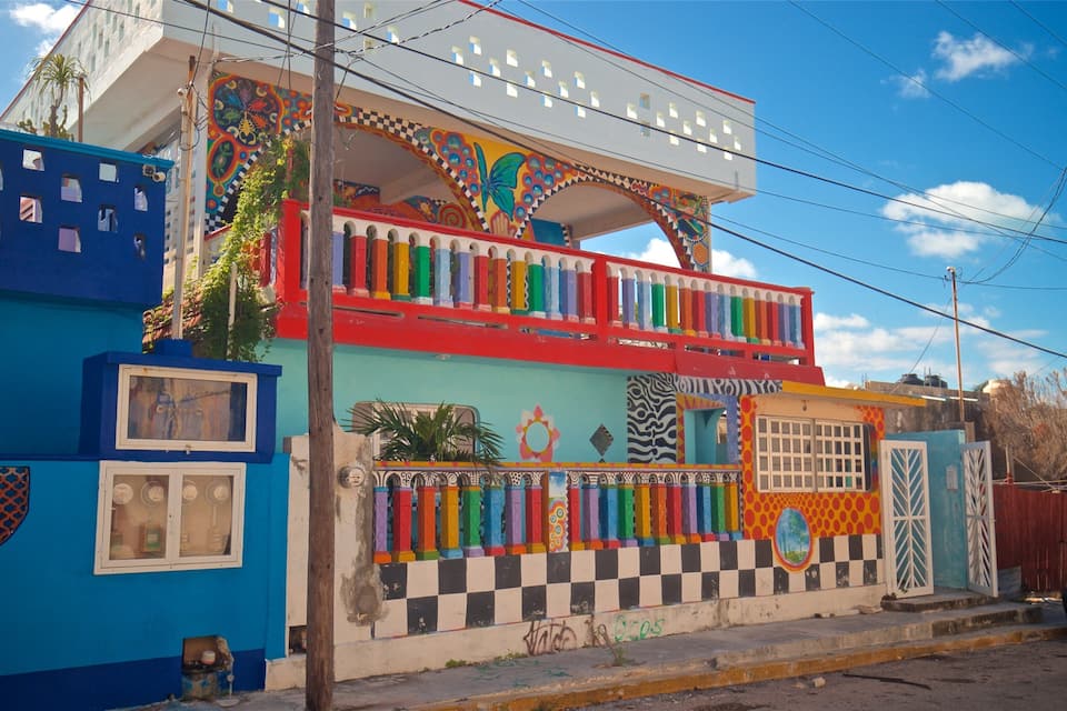 A colorful building with vibrant murals and a checkered pattern on the lower level.