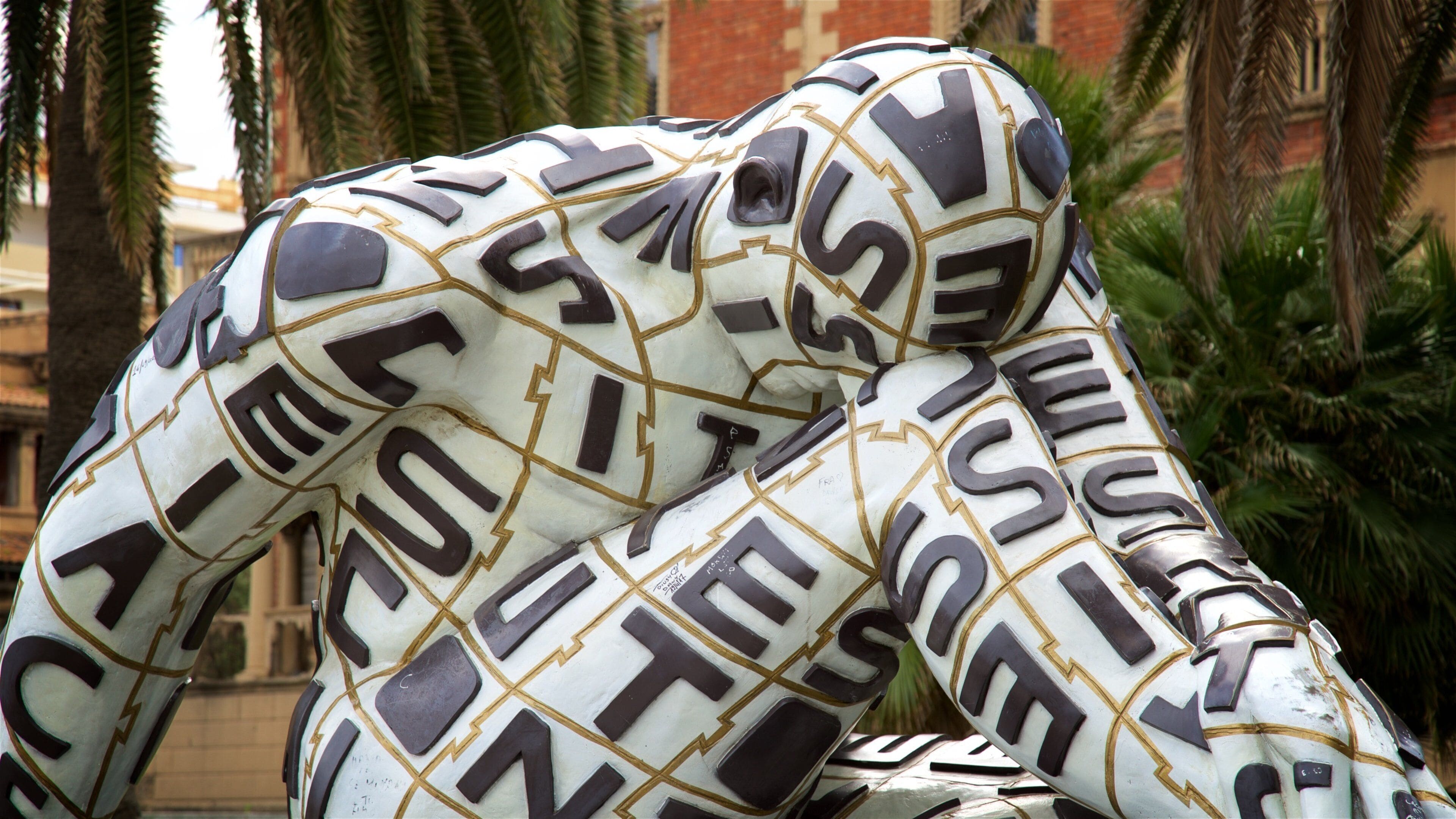 A sculpture of two figures intertwined with letters and numbers.