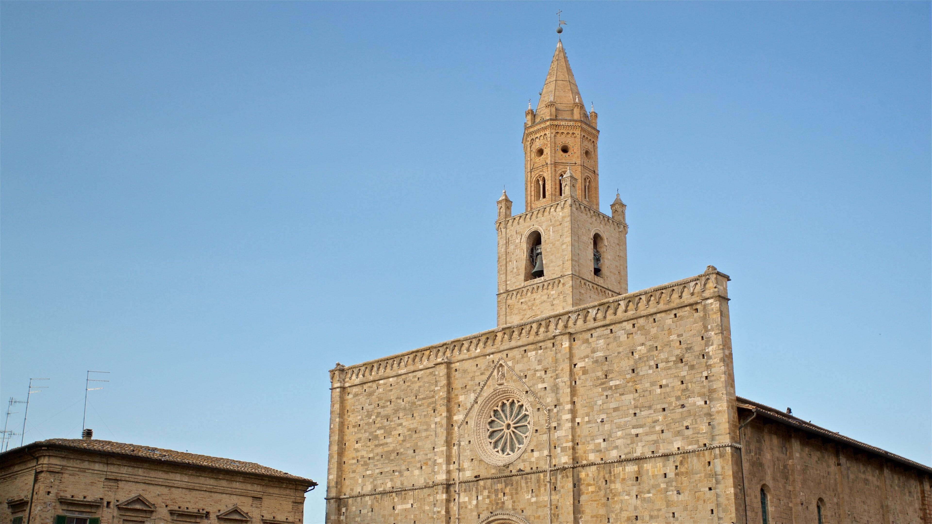 Un edificio histórico con una imponente torre de reloj y un amplio ventanal circular.