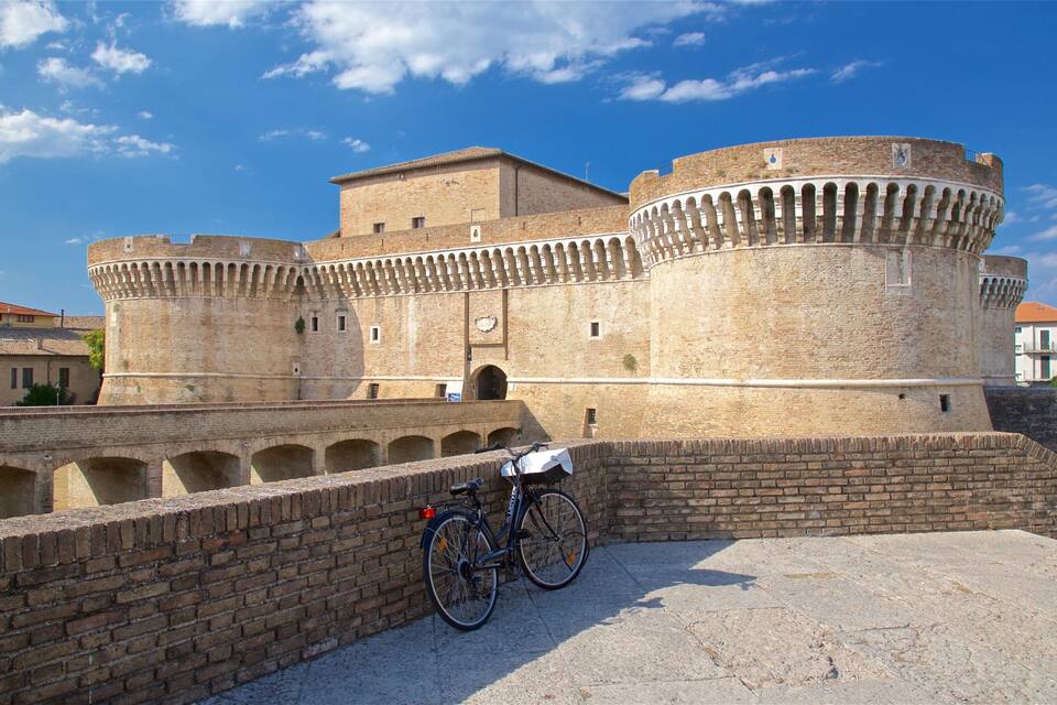 A historic stone fortress with a round tower and arched walkways.