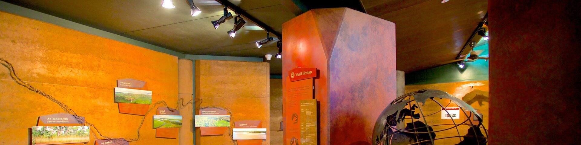 An indoor exhibit with orange walls, a globe, and informational plaques.