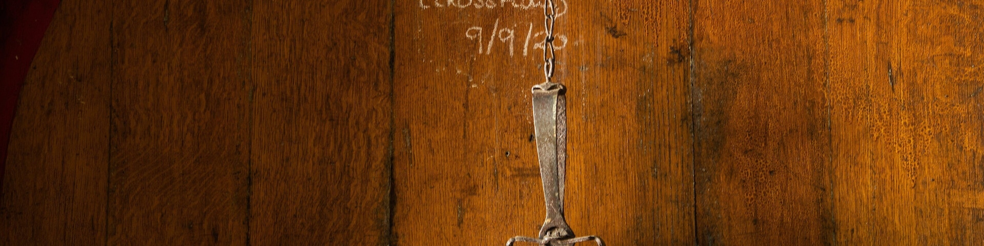 Um barril de madeira com fecho de metal e texto manuscrito.