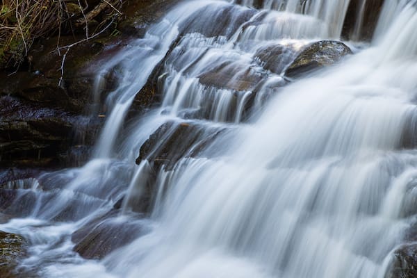 A multi-tiered waterfall with cascading water over rocks.