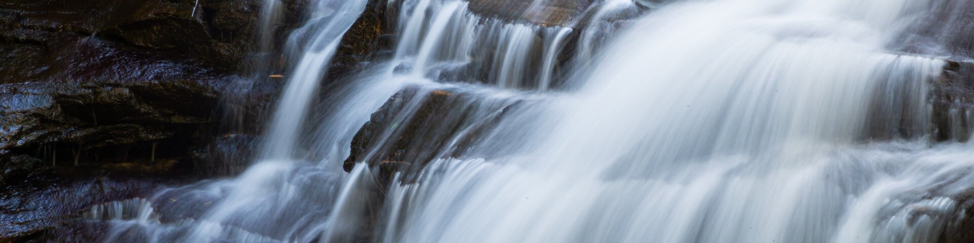 Una cascada de varios niveles con agua que fluye sobre rocas.