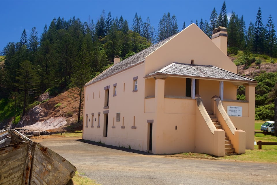 A small museum building with a sign reading "Pier Store Norfolk Island Museum" and a staircase leading to the entrance.