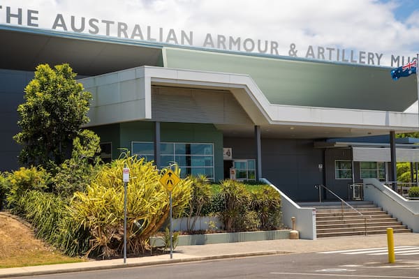 The Australian Armour & Artillery Museum building with a sign, stairs, and surrounding greenery.