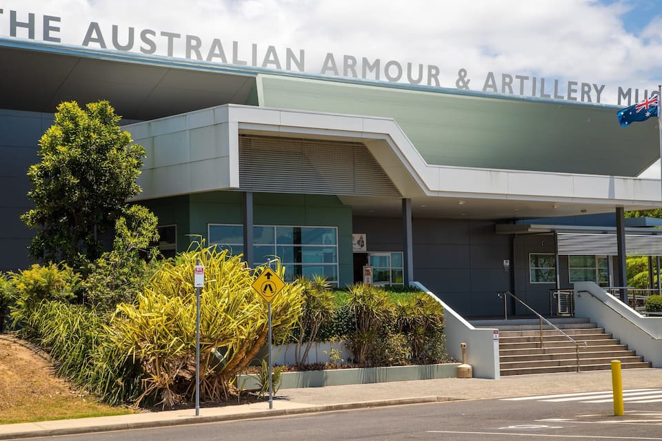 The Australian Armour & Artillery Museum building with a sign, stairs, and surrounding greenery.
