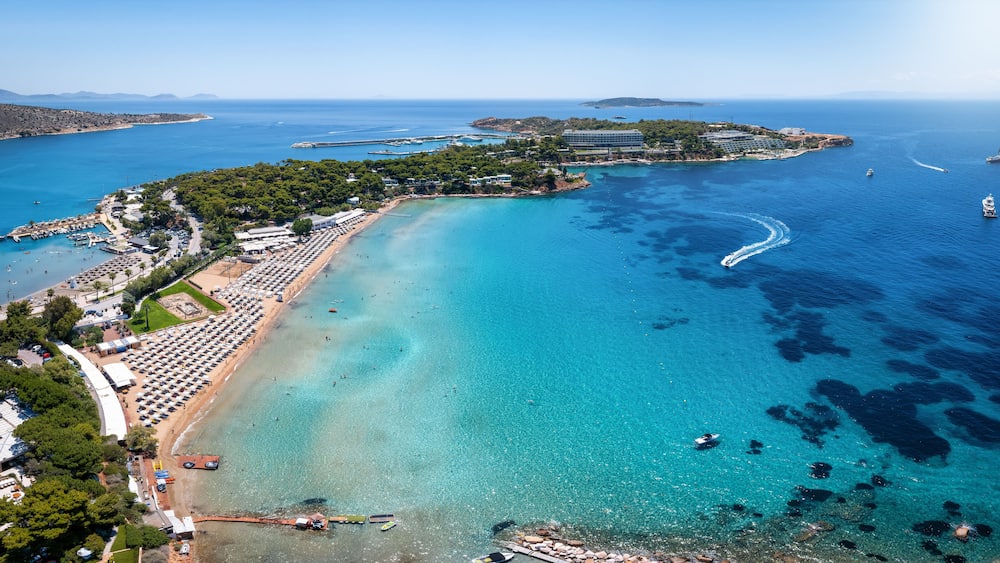 Aerial view of the beautiful beach of Astir at the bay of Vouliagmeni, Athens, with turquoise and emerald sea