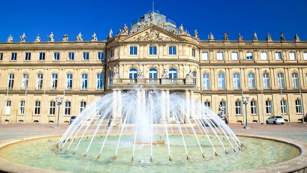 Un imposant bâtiment doté d’une fontaine centrale et de statues sur le toit.