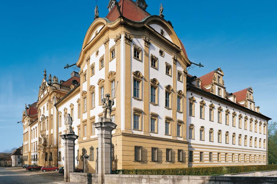 A historic building with ornate architecture, large windows, and statues.
