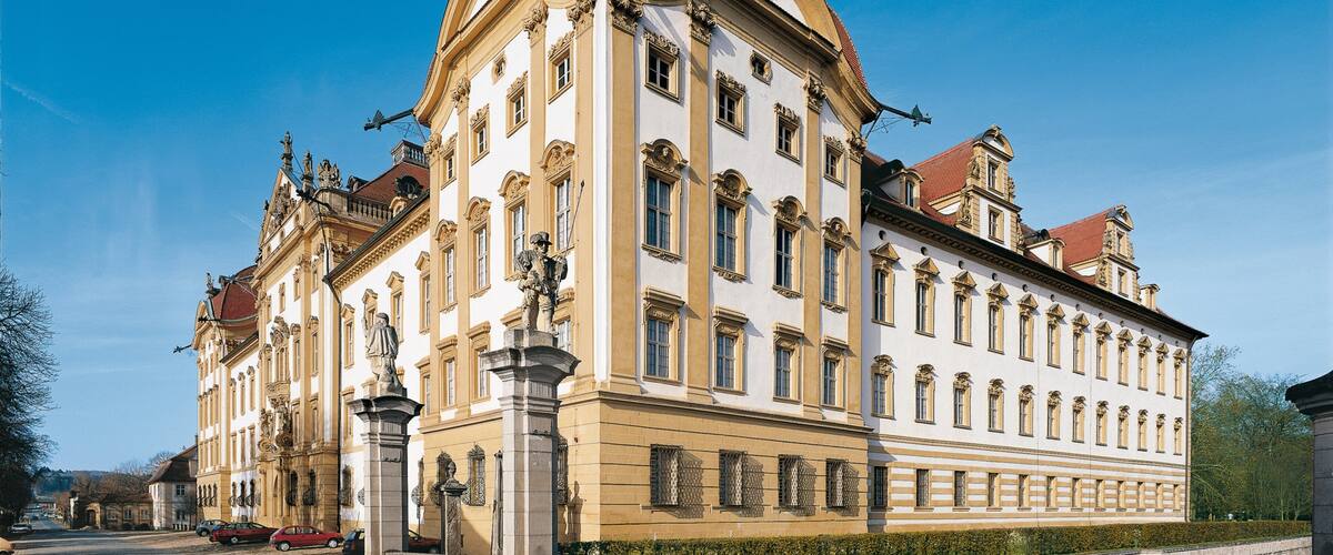 A historic building with ornate architecture, large windows, and statues.