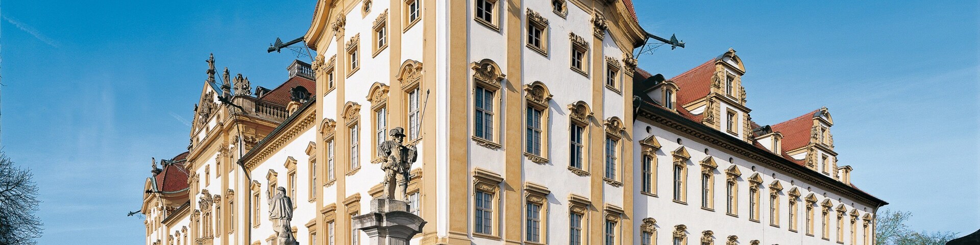 A historic building with ornate architecture, large windows, and statues.