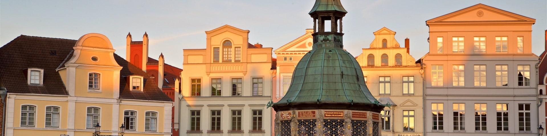 Wasserkunst mostrando elementos de patrimônio, um pôr do sol e uma cidade