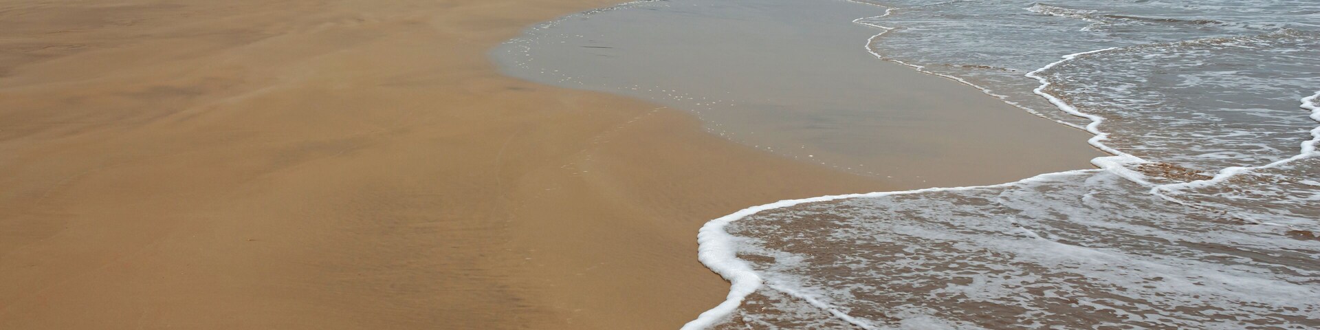 Guhagar beach view with small waves and large expanse of sand. Ratnagiri Konkan, Maharashtra, India.