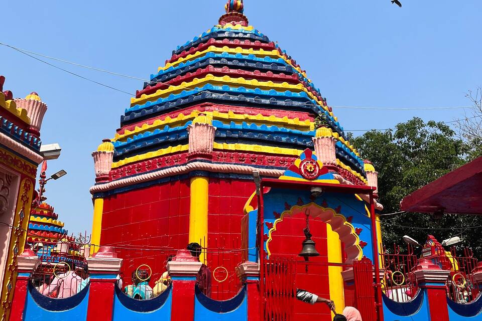 Un temple aux couleurs vives, doté d’un toit à plusieurs niveaux et d’une façade rouge et bleue.
