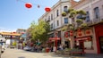 A street lined with traditional buildings, red lanterns, and a sign for Cathay Living.
