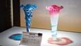 Two glass flower vases with labels.