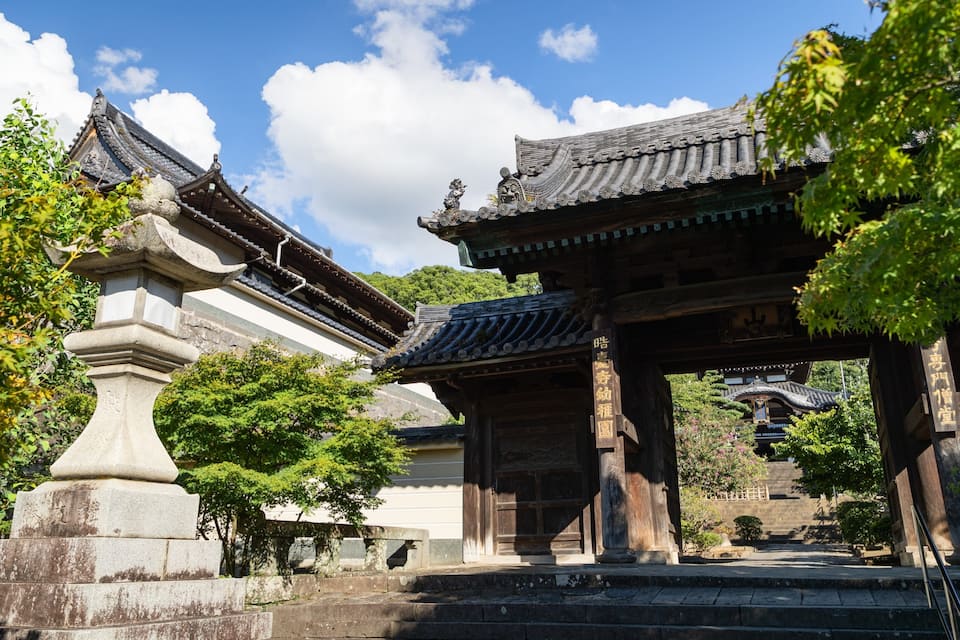 A traditional Japanese temple with ornate architecture, including curved roofs and wooden structures.