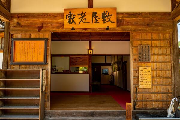 Un bâtiment japonais traditionnel, caractérisé par son architecture en bois et une enseigne ornée de caractères japonais.