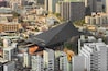 High angle view of the huge triangular shape modern building in color stainless steel of Reiyūkai Shakaden buddhist temple in Azabudai residential district of Tokyo.