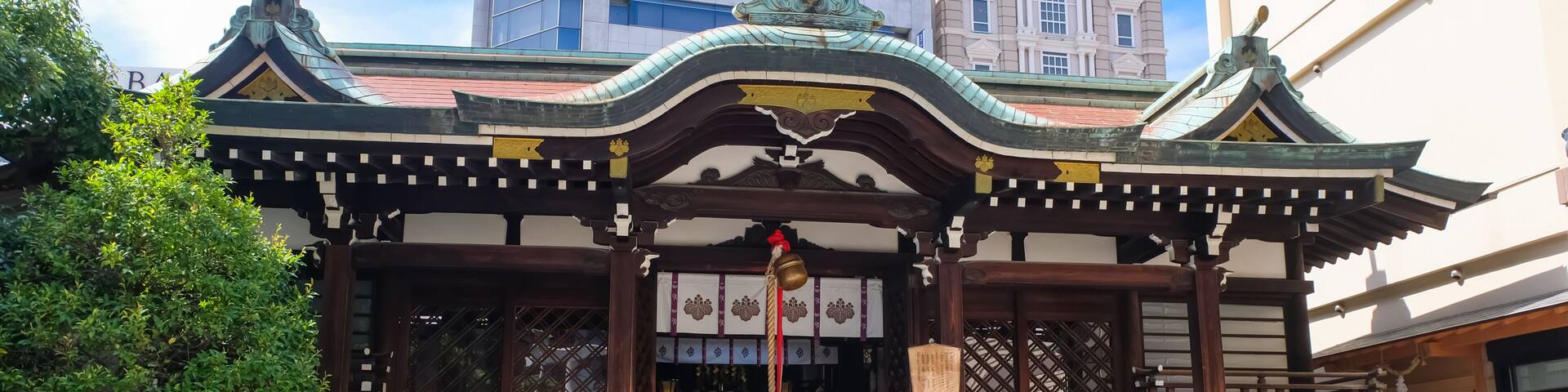 A traditional Japanese building with a tiled entrance, surrounded by potted plants and a decorative map.