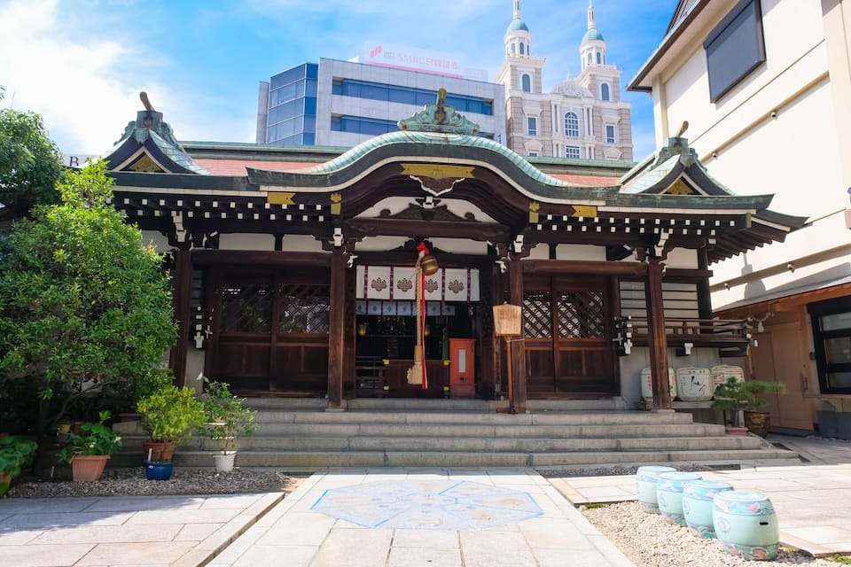 A traditional Japanese building with a tiled entrance, surrounded by potted plants and a decorative map.