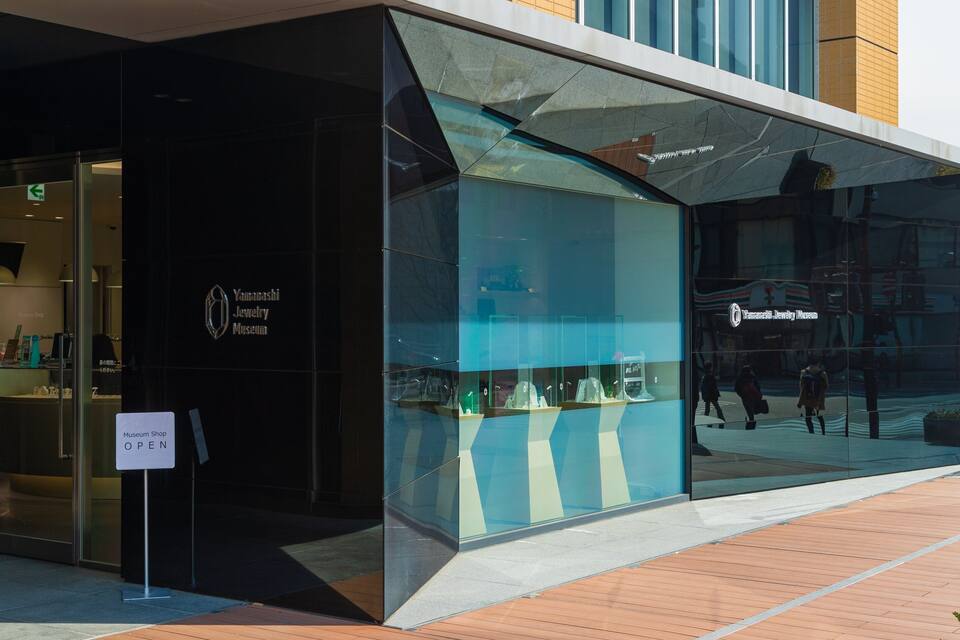 A modern building with glass windows and a sign indicating the Yamashita Jewelry Museum.