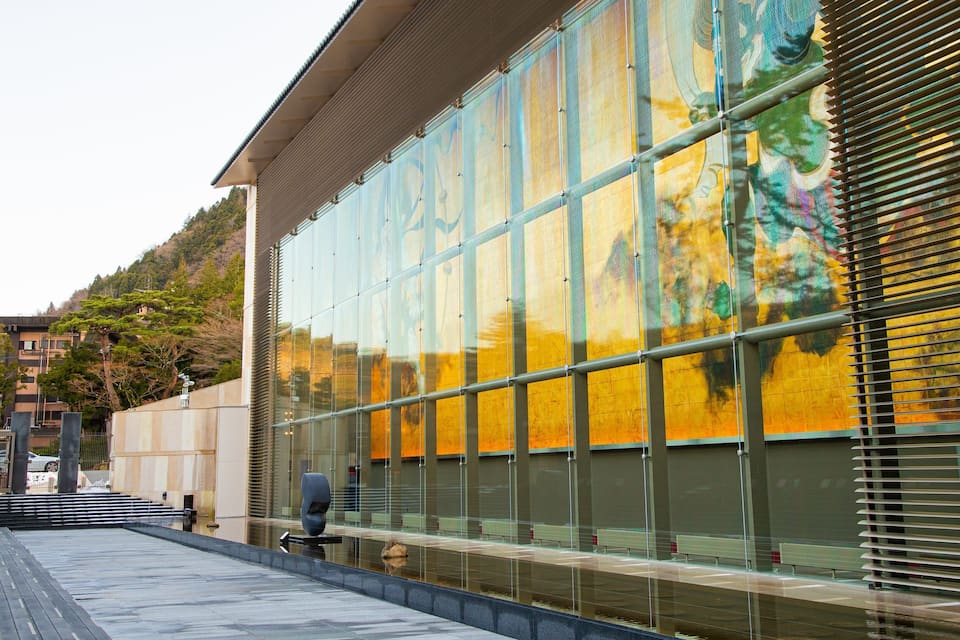 Un edifici modern amb grans finestres de vidre que reflecteixen el paisatge circumdant.
