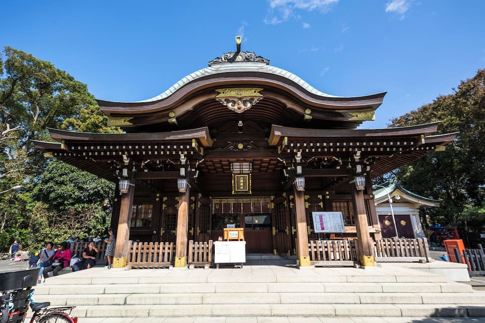 A traditional Japanese temple with a curved roof and wooden pillars.