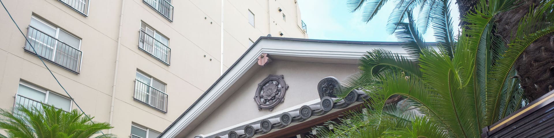 A traditional building with a tiled roof, large windows, and a sign above the entrance.
