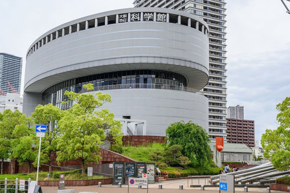 A modern building with a curved facade and signage in a foreign language.
