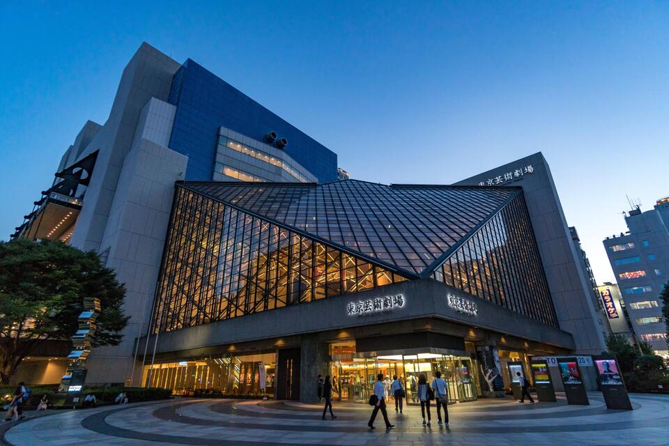 Um edifício moderno com fachada de vidro e design geométrico singular.